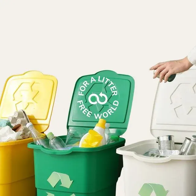 Hand placing items into household recycling bins with plastic bottles and cans, supporting local bottle recycling in the UAE Hand placing items into household recycling bins with plastic bottles and cans, supporting local bottle recycling in the UAE