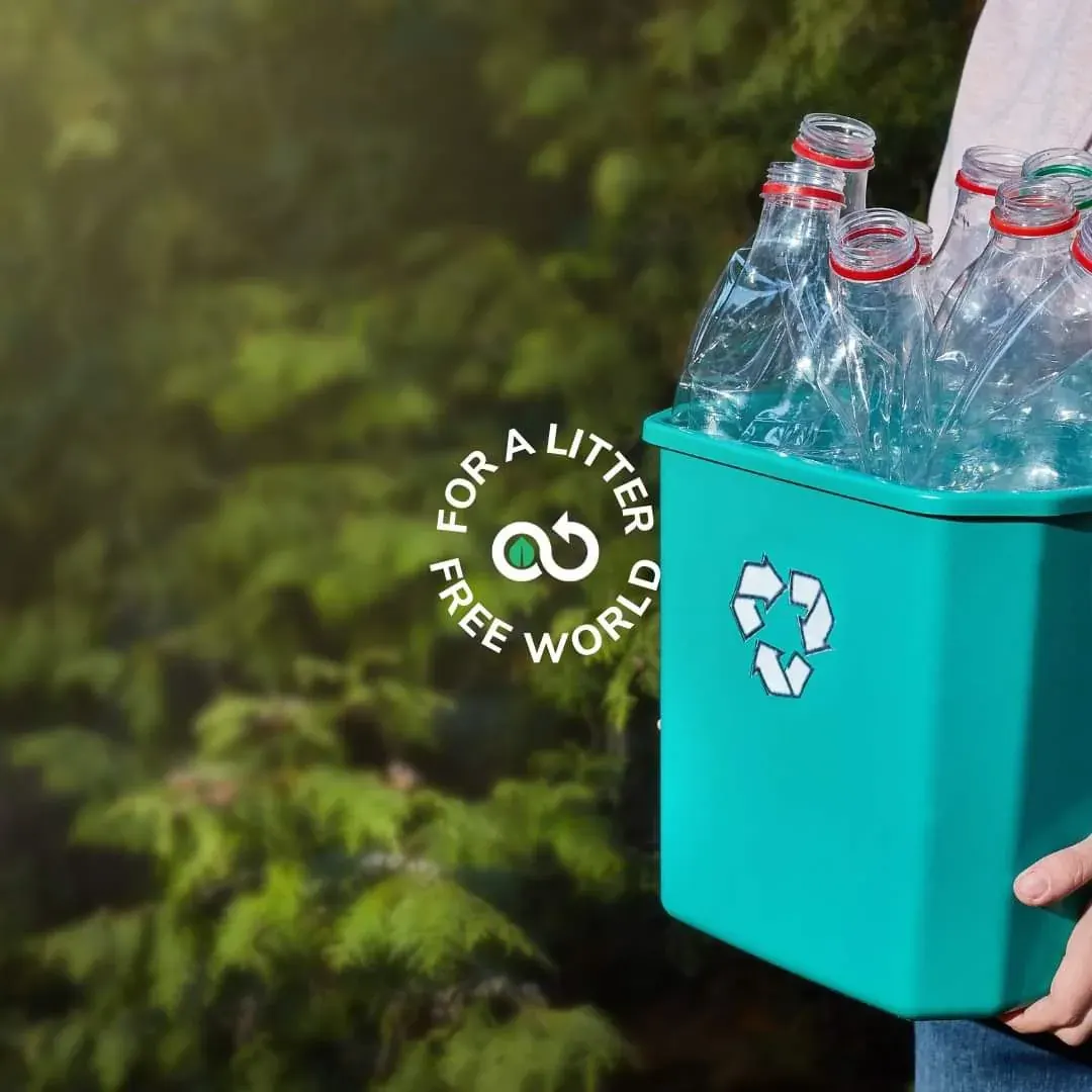 Person holding a recycling bin filled with plastic bottles, supporting plastic bottle recycling efforts in Dubai Person holding a recycling bin filled with plastic bottles, supporting plastic bottle recycling efforts in Dubai